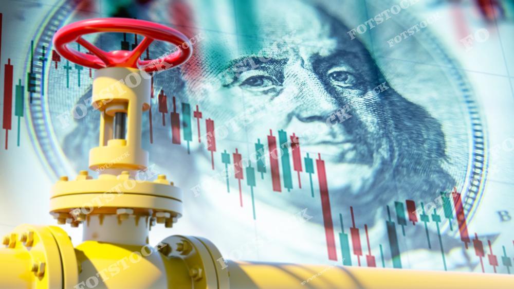 На изображении показан желтый газовый вентиль с красной рукояткой на фоне крупного изображения банкноты и графика колебаний цен. Фотография символизирует взаимосвязь между рынком энергоресурсов и экономикой, подчеркивая влияние стоимости газа на мировые финансы.